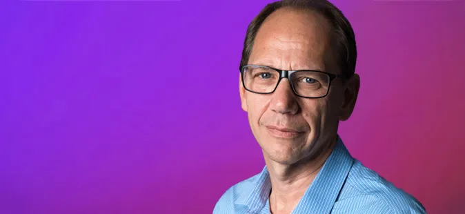 Profile of Lee Rochford, Atom Chair, against a purple and pink gradient background